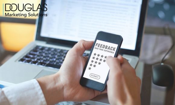 Hände mit Handy in der Hand vor Laptop